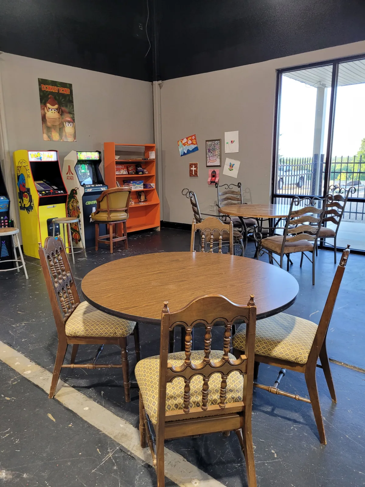 Table seating, arcade games, and board games inside Game On